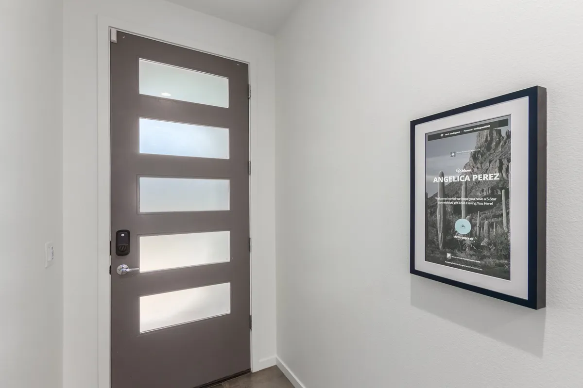 The entryway of the home, featuring a modern door and framed artwork, creates an inviting threshold between outdoor adventures and indoor comforts. It signals a welcoming attitude for guests and their pets right from the moment of arrival.