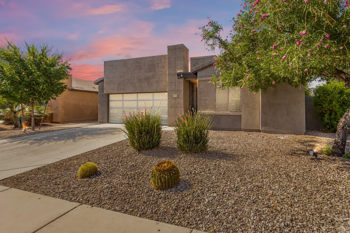 An exterior view showcases the home's modern architecture, lush landscaped garden, and driveway. The garden space hints at walkable areas and a tranquil environment, aligning with the section’s focus on outdoor walks and pet enjoyment. The image conveys a welcoming first impression and community integration.