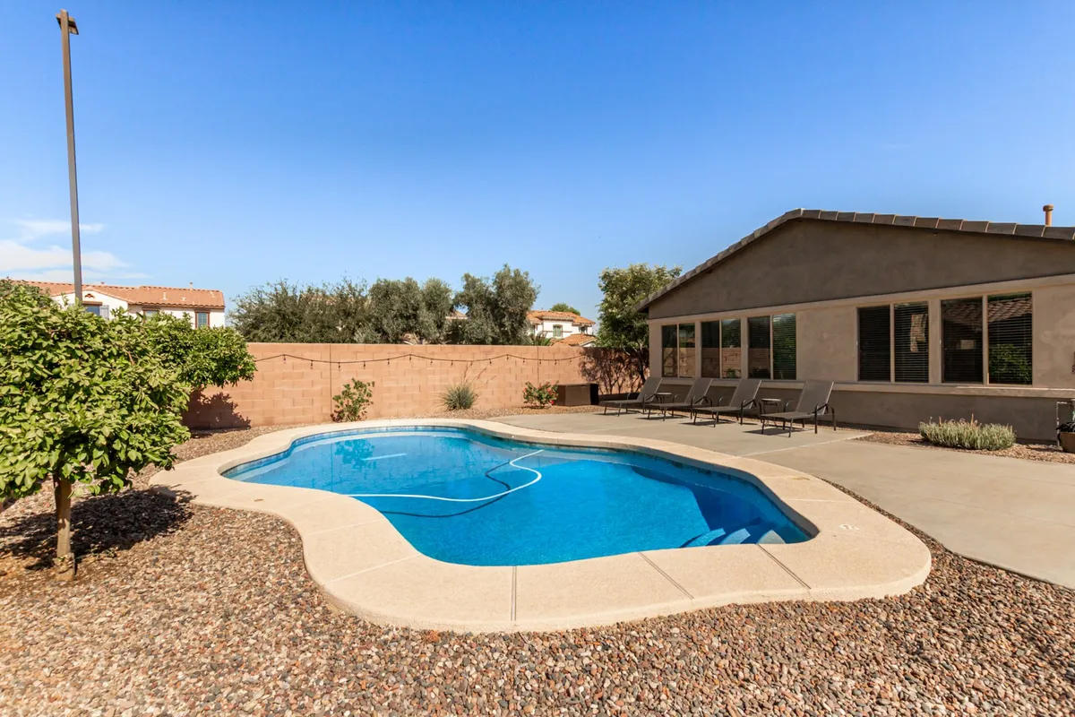 Another inviting exterior image featuring a backyard swimming pool, patio seating area, and thoughtful landscaping. The atmosphere is serene yet social, suggesting both lively poolside parties and quiet mornings with coffee by the water.